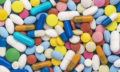 Heap of medical pills in white, blue and other colors.  Concept of healthcare and medicine.