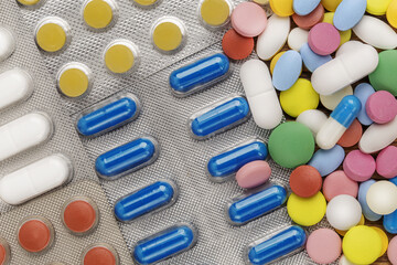 Heap of medical pills in white, blue and other colors.  Concept of healthcare and medicine.