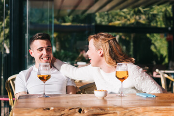 Friends drinking beer at rooftop bar supporting small business. Genuine friendship lifestyle concept with men and women spending happy hour together in pub