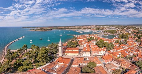 Naklejka na ściany i meble Drone panorama over the roofs of the Croatian coastal town of Novigrad with harbor and church during daytime