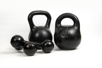 Naklejka na ściany i meble Sports equipment for sports at home or in the gym - iron dumbbells and kettlebells in black on a light background