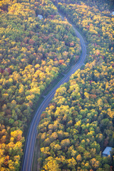Aerial view of curving road among trees in autumn color in northern Minnesota