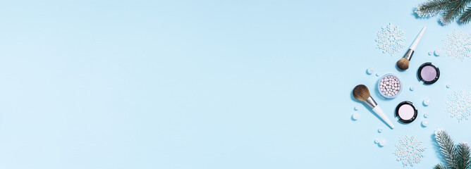 Long wide banner with  decorative cosmetic products and shining decorations on light blue background. Christmas and New Year cosmetic sale and promo banner.