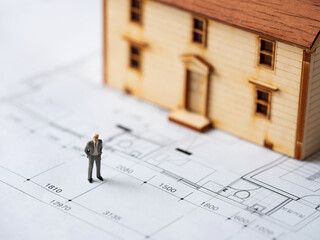 Business man miniature and house miniature on interior drawing