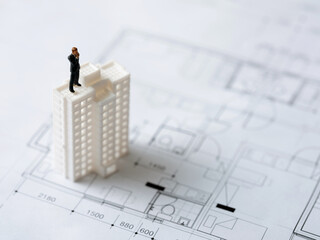 Business man miniature and apartment miniature on interior drawing