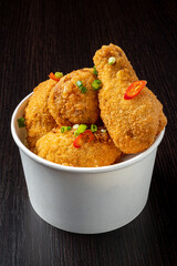 Portion of fried chicken nuggets with fresh vegetables