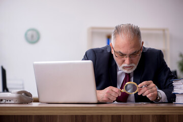 Old male employee working in the office
