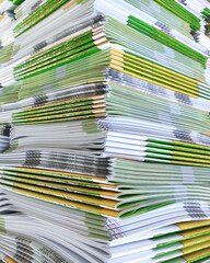 Lot of books stacked in layers in huge endless wall of knowledge. Industrial printing house. Book spines folded into stacks before trimming. Library background, typography, bookstore. Corner view