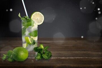 Refreshing summer mojito cocktail with ice cubes, fresh mint and lime on the desk