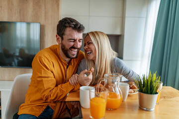 Young couple eating beakfast in kitchen together