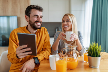 Young couple eating beakfast in kitchen together