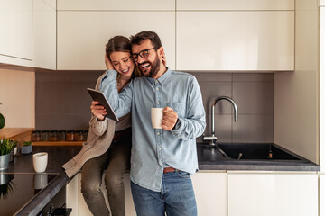 Young couple drinking hot coffee in kitchen