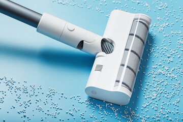 The turbo brush of the vacuum cleaner cleans white balls, top view on a blue background. The concept of cleanliness and cleaning.