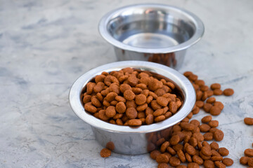 dry animal food in a bowl on a concrete background
