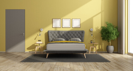 Modern bedroom with yellow walls and gray bed