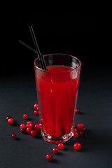 Glass of cranberry juice on black background