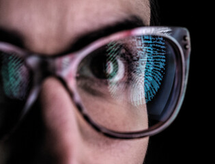 Woman with a reflection of a finger print on her glasses to represent identity and access