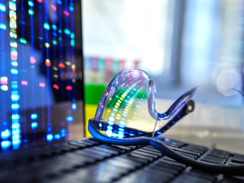 DNA profile results reflecting in protective glasses lying on laptop keyboard
