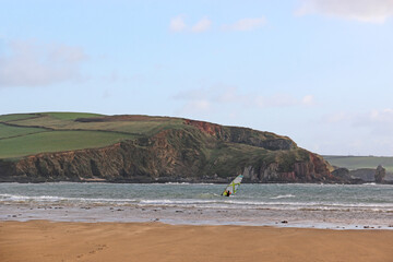 Windsurfers off Bigbury Beach, Devon, at low tide