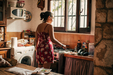 Rear view of woman cooking in kitchen