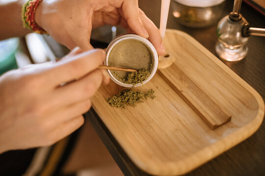 Young man preparing marijuana in a sieve