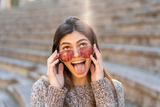 Playful young woman wearing sunglasses and grimacing