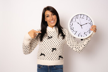 portrait of a beautiful young woman holding a big clock isolated over white background.