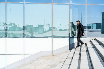 Businessman on cell phone walking down stairs in the city