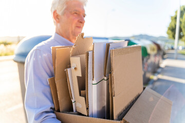 Senior man recycling cardboard carrying cardboard box