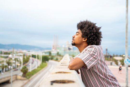 Young hipster on viewpoint, city in the background