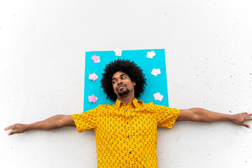 Young man wearing yellow shirt, blue indicating label with arrow signs