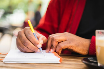 Hand of mature man drawing at street cafe, close-up