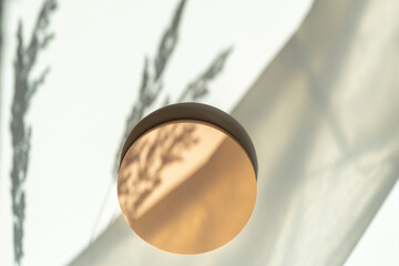 Empty round pastel beige platform podium on white background with natural light and shadows. Mock...