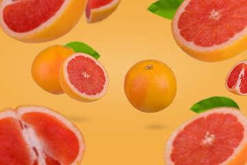 Creative idea with whole and sliced grapefruit floating in the air  isolated on orange background.