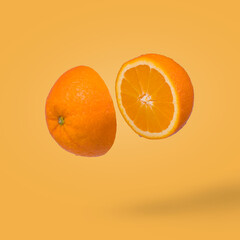 Minimal idea with juicy orange cut in two halves flying in the air.