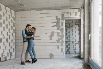 Happy couple of future owners at construction site