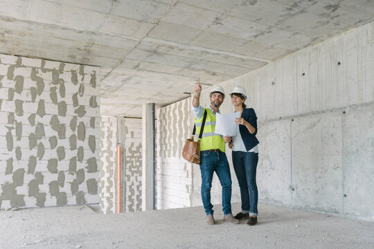 Male architect and female manager talking at construction site