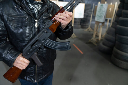 Crop view of senior man with a gun in shooting range
