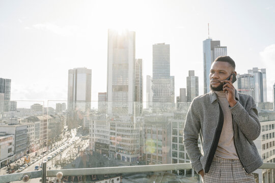 Stylish man on the phone on observation terrace with skycraper view, Frankfurt, Germany