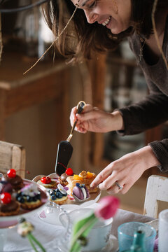 Woman arranging pastries on cake stand