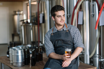 Young man drinking a beer at a brewery