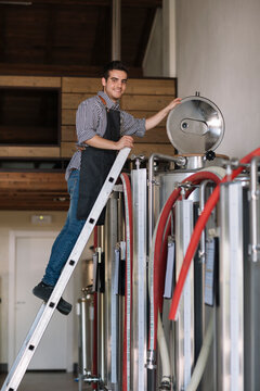 Young entrepreneur working at tank at a brewery
