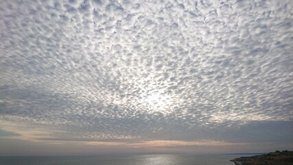 Fototapeta premium The sun disappeared behind the clouds over the sea. The sea without horizon goes into the clouds.