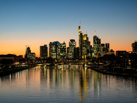 Germany, Hesse, Frankfurt, Skyline of financial district, Main river and Deutschherrn Bridge at sunset