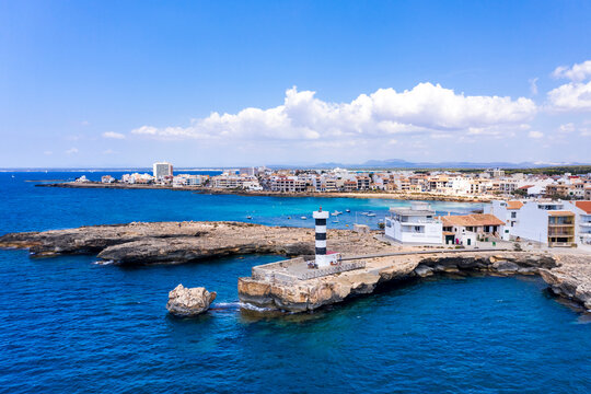 Spain, Balearic Islands, Colonia de Sant Jordi, Coastal lighthouse with city in background
