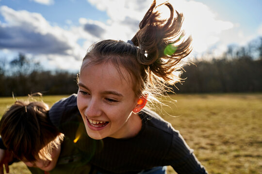 Carefree girl playing with brother on a meadow