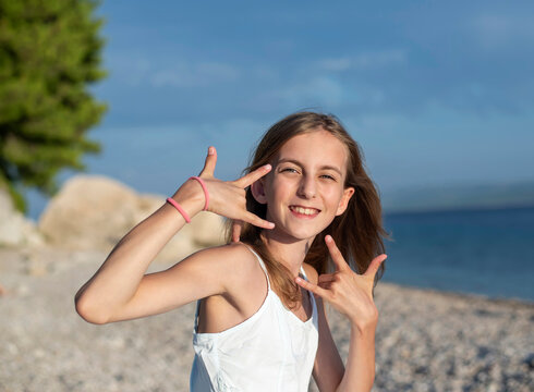 Croatia, Lokva Rogoznica, portrait of gesticulating girl on the beach