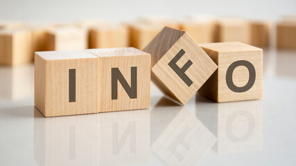 the word info is written on a wooden cubes structure. Blocks on a bright gray background. Selective...