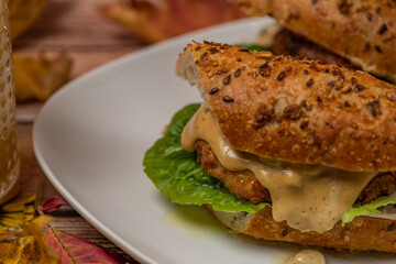 Chicken burger in seeds baguette with olive jalapenos dressing with pear juice