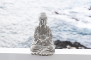Concrete buddha figure, ocean in the background